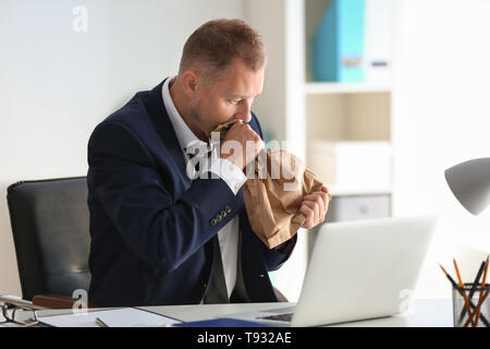 Man having panic attack at workplace in office Stock Photo