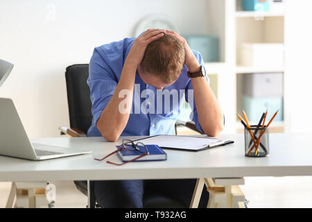 Man having panic attack at workplace in office Stock Photo