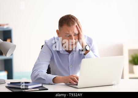 Man having panic attack at workplace in office Stock Photo