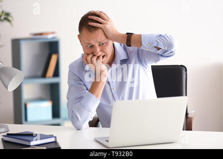 Man having panic attack at workplace in office Stock Photo