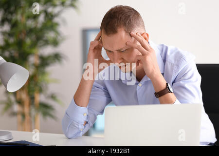 Man having panic attack at workplace in office Stock Photo