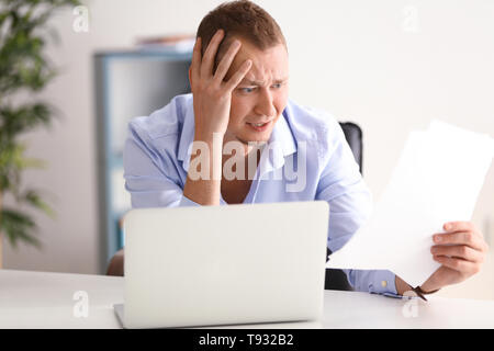 Man having panic attack at workplace in office Stock Photo