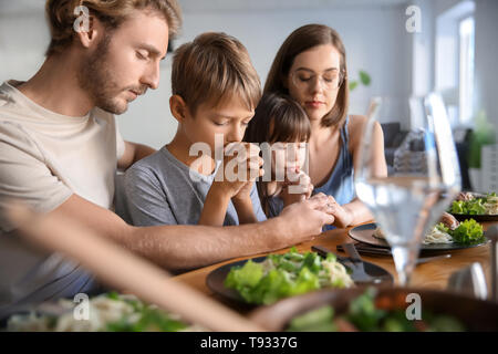 Family praying before meal at home Stock Photo