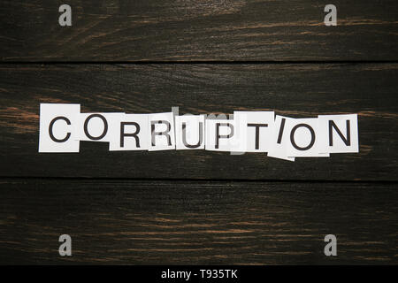 Pieces of paper with word CORRUPTION on wooden background Stock Photo