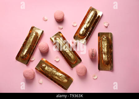 Flat lay composition with delicious eclairs on color background Stock Photo