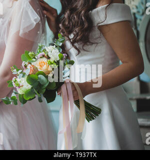 Bride and bridesmaids. Beautiful young women in dresses and with bouquets of fresh flowers. Bridal bouquet, close-up Stock Photo