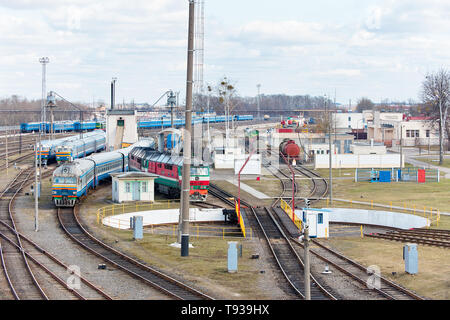 Diesel locomotives and carriages stand in depot near railway turntable. Stock Photo