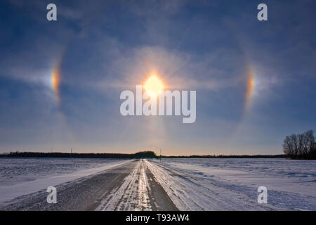 Sundogs and country road on prairie landscape Grande Pointe Manitoba Canada Stock Photo