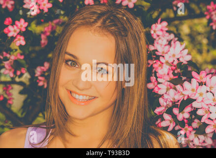 Portrait of young woman in the flowered garden for background. Stock Photo
