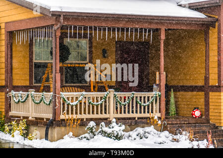 Rustic brown home in Daybreak Utah viewed through falling snow in winter Stock Photo
