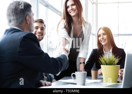 Welcome to our team! Business people shaking hands while working in the creative office Stock Photo