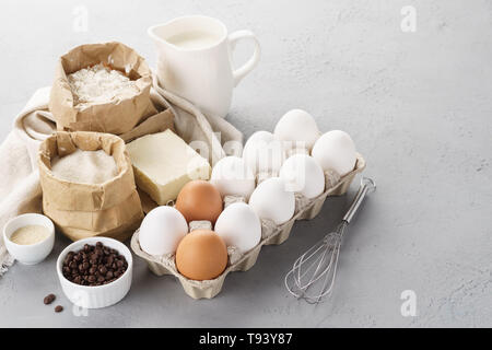 Various baking ingredients for sweet pastry. Dough recipe. Milk, flour, eggs, sugar and butter. Copy space Stock Photo