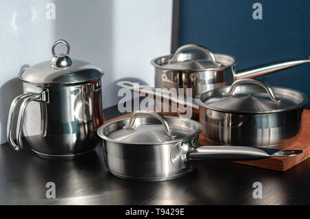 Stainless steel pots and utensils on table counter Stock Photo