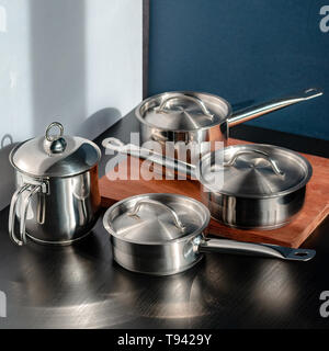 Stainless steel pots and utensils on table counter Stock Photo