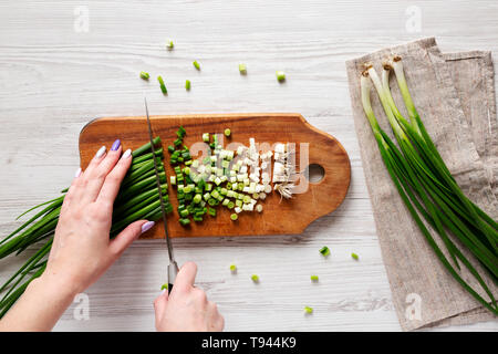 Woman chopping green onions, overhead view. Top view, from above. Stock Photo