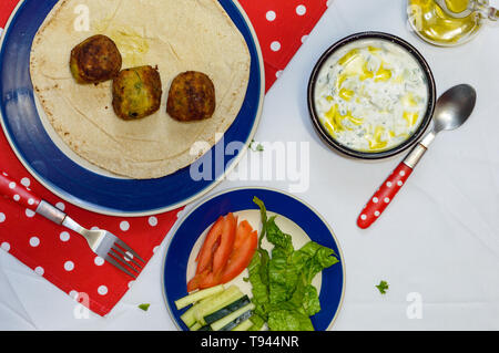 Cooked falafel on table with vegetables and yogurt sauce. Concept for cooking, restaurants, menus, healthy eating, vegetarian and vegan diet, food blo Stock Photo