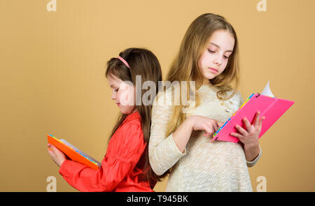 Friendship and sisterhood. students reading a book. School project. workbooks for writing. Back to school. small girls with note books. happy little children ready for lesson. Inspired to work hard. Stock Photo