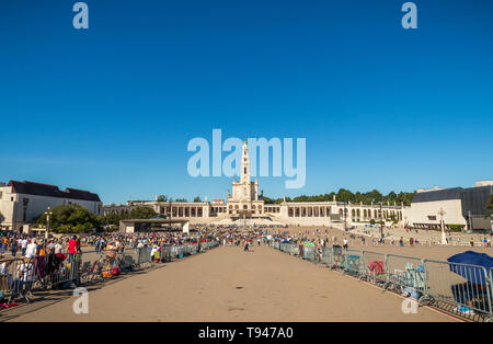 Fatima, Portugal - May 12, 2019: View of the Shrine of Fatima with the background basilica and pilgrims waiting for the candle procession and visit to Stock Photo