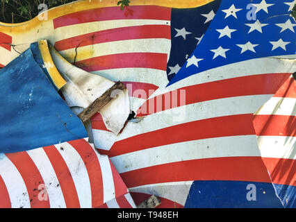 Broken flag, demolished background cardboard with American flag 'Stars and Stripes' as motive, disposed at the roadside. Stock Photo