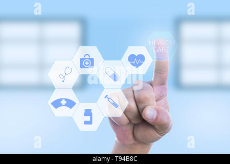 Medic man pressing healthcare button by using index finger on invisible screen with symbols Stock Photo