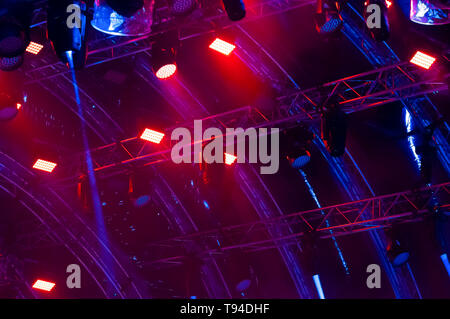 Blue neon light. Colorful concert lighting. Rays of light from concert lighting on a dark background above the projector screen. Stock Photo