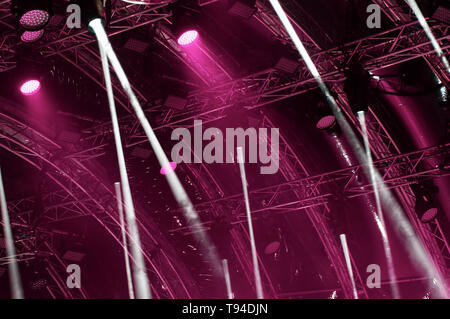 Blue neon light. Colorful concert lighting. Rays of light from concert lighting on a dark background above the projector screen. Stock Photo