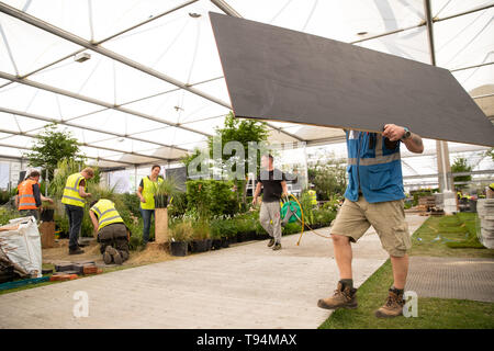 Equipment is carried during preparations for the RHS Chelsea Flower Show at the Royal Hospital Chelsea, London. Stock Photo