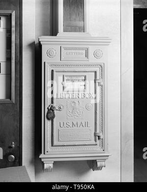 Entitled: 'U.S. Mail letter box in elevator lobby on main lobby level at Commercial National Bank, 20 East Martin Street, Raleigh, Wake County, North Carolina.' A post box, also known as a collection box, mailbox, letter box or drop box is a physical box into which members of the public can deposit outgoing mail intended for collection by the agents of a country's postal service. Stock Photo