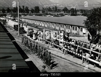 Entitled: 'Japanese waiting for registration at the Santa Anita reception center.' The internment of Japanese-Americans during WWII was the forced relocation and incarceration in camps of 110,000-120,000 people of Japanese ancestry (62% of the internees were US citizens) ordered by President Roosevelt shortly after Japan's attack on Pearl Harbor. Japanese-Americans were incarcerated based on local population concentrations and regional politics. Stock Photo