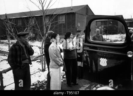 Entitled: 'Relocation departure II, Manzanar Relocation Center.' The internment of Japanese-Americans during WWII was the forced relocation and incarceration in camps of 110,000-120,000 people of Japanese ancestry (62% of the internees were US citizens) ordered by President Roosevelt shortly after Japan's attack on Pearl Harbor. Japanese-Americans were incarcerated based on local population concentrations and regional politics. Stock Photo