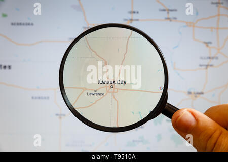 Kansas City, United States. Political map. The city on the monitor screen through a magnifying glass in hand. Stock Photo