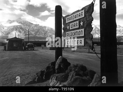 Entitled: 'Entrance to Manzanar, Manzanar Relocation Center.' The internment of Japanese-Americans during WWII was the forced relocation and incarceration in camps of 110,000-120,000 people of Japanese ancestry (62% of the internees were US citizens) ordered by President Roosevelt shortly after Japan's attack on Pearl Harbor. Japanese-Americans were incarcerated based on local population concentrations and regional politics. Stock Photo