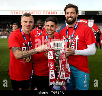 Lincoln City's Harry Anderson (left to right), Tom Pett (centre) and Josh Vickers (right) celebrate with the trophy Stock Photo