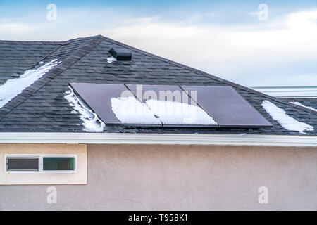 Solar panels on the roof of a home against blue sky with clouds Stock Photo