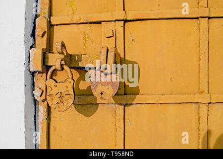 Antique iron-bound door with a latch on two locks close-up. The concept of the template is hidden or falsified secrets of history. Stock Photo
