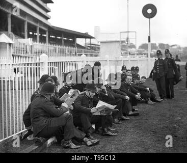British policemen checking for racing tips at the Epsom Derby races in June 1932 Stock Photo