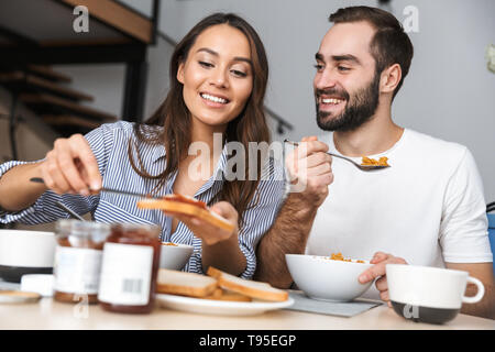 Happy multiethnic couple having breakfast at the kitchen Stock Photo
