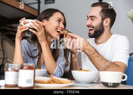 Happy multiethnic couple having breakfast at the kitchen Stock Photo
