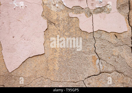 Beautiful background of rough rustic texture the shabby Old ruined wall of the historic building with pink cracked plaster and cement Stock Photo