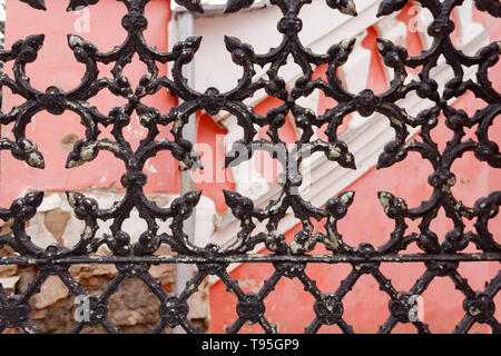 Old building with openwork grunge old rusty black painted metal texture cracked lattices. The architectural element of the decoration of the old build Stock Photo
