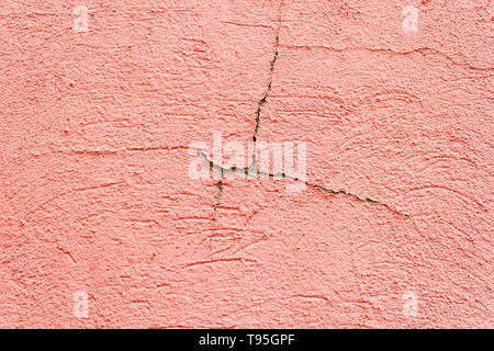 Beautiful background of rough rustic texture the shabby Old ruined wall of the historic building with pink orange salmon cracked plaster Stock Photo