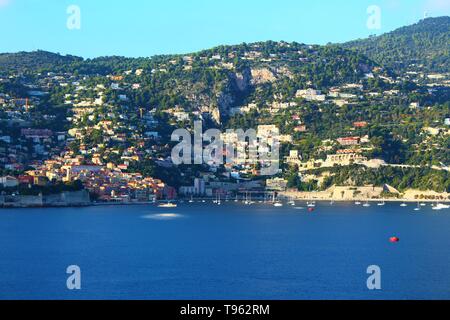 Scenic late afternoon view of the bay of Villefranche-sur-Mer and the surrounding mountain landscape. Stock Photo