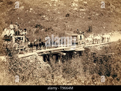 The Deadwood Coach in 1889: two stagecoaches crossing a bridge, with the men waving or tipping their hats to the photographer,  John C. H. Grabill. Deadwood, a city in South Dakota, is a National Historic Landmark District for its well-preserved Gold Rush-era architecture. Stock Photo