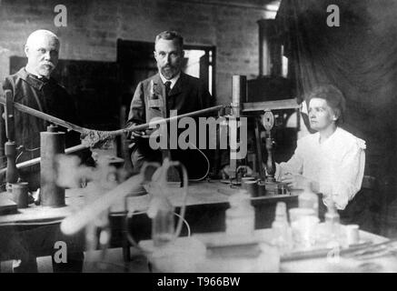 Marie and Pierre Curie (center) in their laboratory in Paris with unidentified man. Pierre Curie was introduced to Maria Sklodowska by a friend and took Maria into his laboratory as his student. He began to regard her as his muse. She refused his initial proposal, but finally agreed to marry him on July 26, 1895. Marie Curie (November 7, 1867 - July 4, 1934) was a Polish-French physicist and chemist. Stock Photo