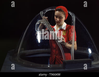Phyllis Ann Marxson Clark, an 18 year old North Dakota native, in a glass house is putting finishing touches on the bombardier nose section of a B-17F navy bomber, Long Beach, Calif. She's one of many capable women workers in the Douglas Aircraft Company plant. Although the image of 'Rosie the Riveter' reflected the industrial work of welders and riveters, the majority of working women filled non-factory positions in every sector of the economy. . Photographed by Alfred T. Palmer, 1942. Stock Photo