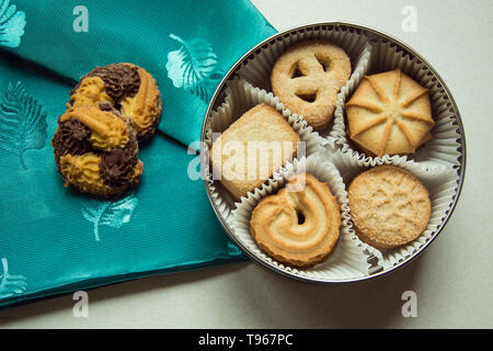 Cookies with sugar in a round box and two on a green napkin Stock Photo