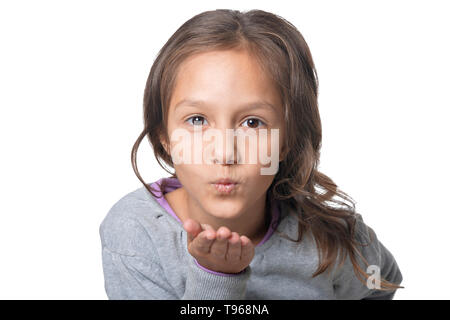 Portrait of cute smiling little girl blowing air kiss on white background Stock Photo