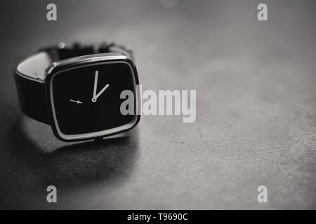 A dark analog clock on a stone surface Stock Photo