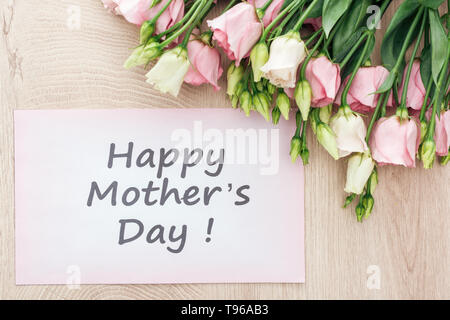 top view of eustoma flowers and card with happy mothers day words on wooden table Stock Photo