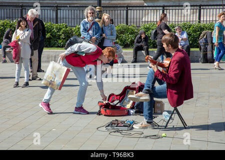 Street performer plays the classical guitar music on Trafalgar Square London, UK on a warm and sunny day in May entertaining tourists and Londoners. Stock Photo